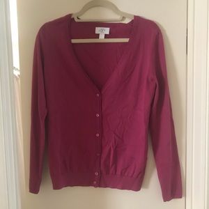 Magenta colored button-up, v-neck cardigan.
